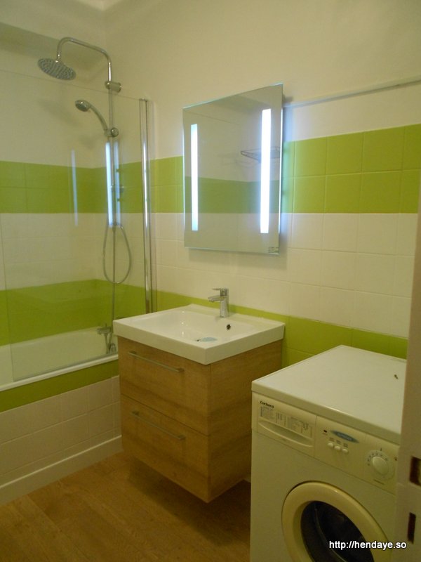 Vue de notre salle de bain couleur blanche et vert anis. Baignoire. Meuble vasque et lave linge